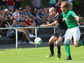 Florian Gundelsheimer (l.) behauptet den Ball auf der Außenbahn, die Zuschauer in Schweinfurt verfolgen seine Aktion. Fotos: Ralf Naumann