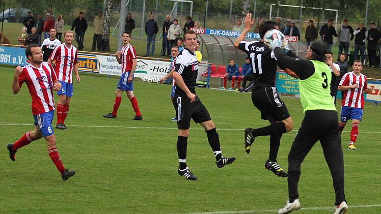 DJK-Torwart Edwin Stierl holt noch dem Sander Peter Heyer (etwas verdeckt) den Ball vom Kopf, links daneben verfolgt Stefan Wasser die Szene.