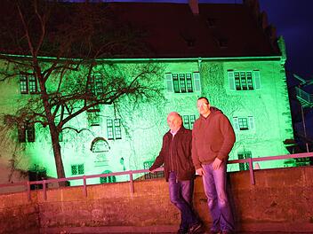 Klaus Frischat und Jürgen Wehner vor dem bunt angeleuchteten Schloss Aschach. Fotos: Ralf Ruppert