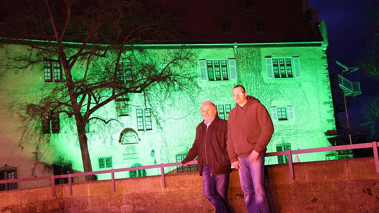 Klaus Frischat und Jürgen Wehner vor dem bunt angeleuchteten Schloss Aschach. Fotos: Ralf Ruppert