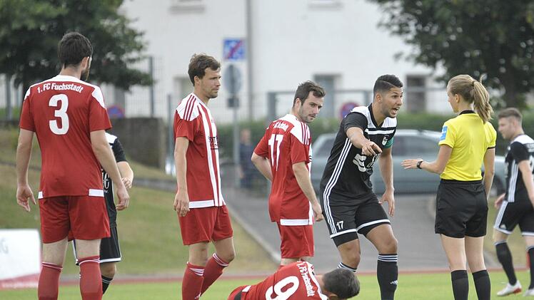Der Coburger Kapitän Sertan Sener (schwarzes Trikot) ist nicht einverstanden mit dem Pfiff von  Schiedsrichterin Davina Haupt nach einem vermeintlichen Foul an Fuchsstadts Lukas Lieb (am Boden).  Foto: Hagen Lehmann