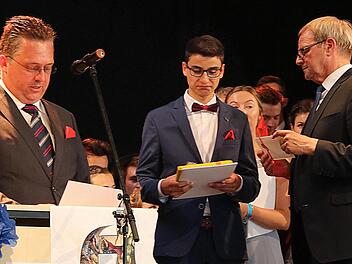 Bester Abiturient des Johann-Philipp-von-Schönborn-Gymnasiums ist in diesem Jahr Tizian Gebert. Schulleiter Joachim Schwigon (rechts) und der Vorsitzende des Fördervereins, Christian Stoßberg, (links) überreichten ihm seine Preise. Foto:  Dieter Britz