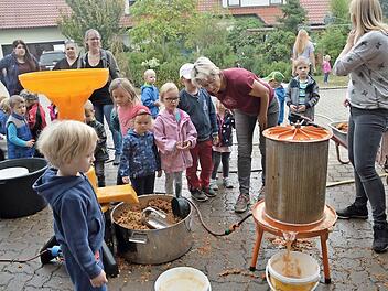 Aus einer mobilen Saftpresse gewinnen die Kinder in Trailsdorf frischen Apfelsaft.  Foto: Mathias Erlwein