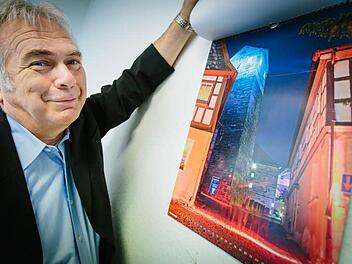 Hartmut Nenninger zeigt sein liebstes Motiv aus dem neuen Kalender. Es zeigt den Stadtturm und einen "Feuerstrahl" auf der Straße.  Foto: Hendrik Steffens