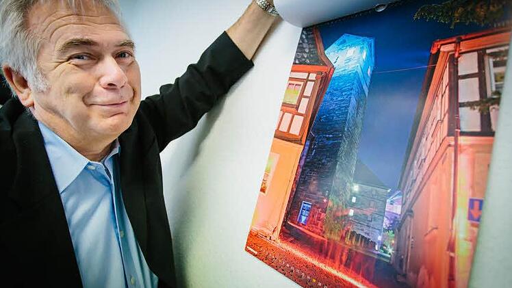 Hartmut Nenninger zeigt sein liebstes Motiv aus dem neuen Kalender. Es zeigt den Stadtturm und einen "Feuerstrahl" auf der Straße.  Foto: Hendrik Steffens