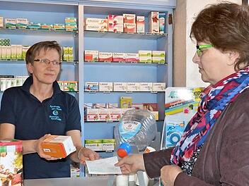 Apothekerin Olga Merdian spricht russisch und hat Hasan stets seine Medikamente gegen Diabetes ausgehändigt. Uschi Schmidt (rechts) löst ein Rezept ein und möchte die Arznei nach Kasachstan schicken. Inzwischen wurden Spendendosen (vorne links) aufgestellt.  Foto: Bernhard Panzer