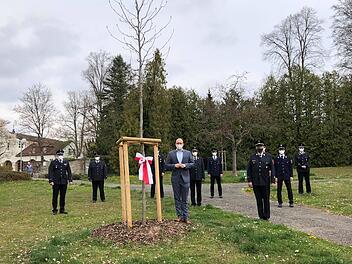 Oberb&uuml;rgermeister Dirk Vogel und die Vertreter der Bad Kissinger Feuerwehren nach der Pflanzung des neuen Tulpenbaumes an der Ecke Vernonstra&szlig;e/Massaplatz.  Foto: Birgit Fischer