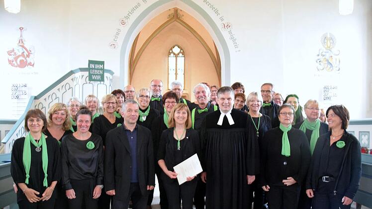 Die Sängerinnen und Sänger des Gospelchores "Lift your  voice" beglückwünschen ihre Chorleiterin für diese besondere  musikalische Würdigung. Im Bild vorne: Dekanatskantor Mark Genzel,  Chorleiterin und Organistin Christel Hentschel und Pfarrer Carsten Friedel.