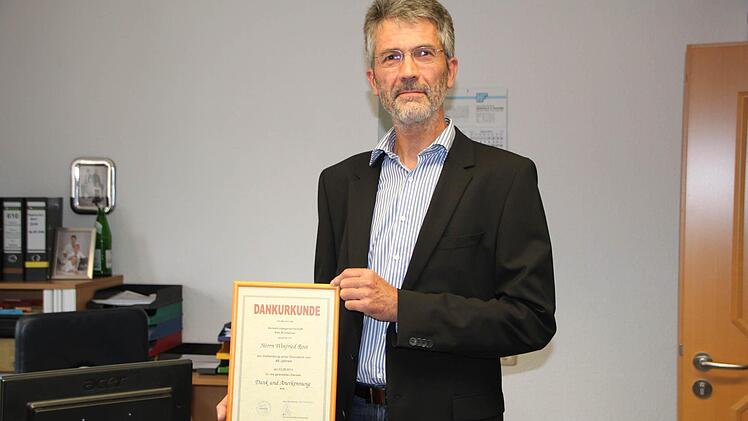 Winfried Rost zeigt die Urkunde zum Dienstjubiläum. Foto: Sebastian Vogt