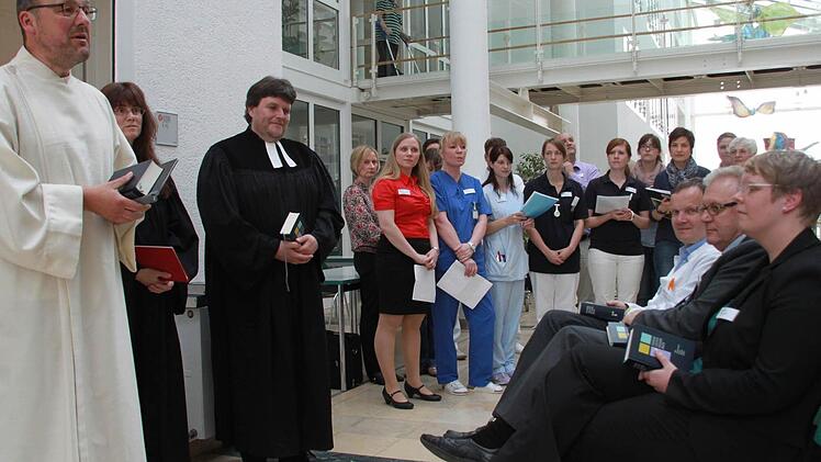 Der katholische Pastoralrefert Josef Ellner sowie Pfarrerin Anja Bautz und Pfarrer Helmuth Bautz (von links) gaben dem neuen "Raum der Stille" den kirchlichen Segen. Im Hintergrund der Schön-Klinik-Chor. Fosos: Matthias Einwag