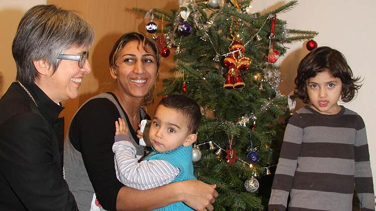 Mane Rashujan ist mit ihrem Mann (nicht im Bild) und drei Kindern nach Deutschland gekommen. Klein-Timur (1) und Irina (4) freuen sich über die Papiersterne, die Regionalbischöfin Dorothea Greiner mitgebracht hat.