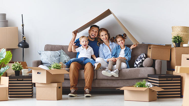 happy family mother father and children move to new apartment and unpack boxes
