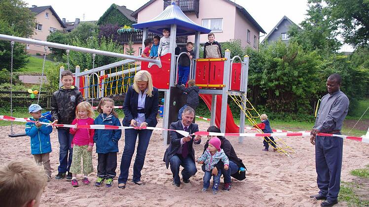 Bürgermeisterin Susanne Grebner, Gerhard Eidelloth und die kleine Lilly Hummel durchschnitten das symbolische rote Band. Mit im Bild ist (rechts) Pater Abbe Raimond. Foto: Heike Schülein