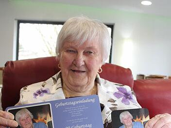 Lisbeth Gärtner hält eine der Geburtstagsüberraschungen hoch: Die Ricolor-Chefs haben für die frisch gebackene Neunzigjährige Frühstücksbrettchen mit dem eigenen Konterfei und die dazu passenden Untersetzer für die große Geburtstagsgesellschaft hergestellt. Foto: Adam