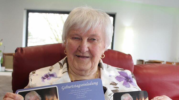 Lisbeth Gärtner hält eine der Geburtstagsüberraschungen hoch: Die Ricolor-Chefs haben für die frisch gebackene Neunzigjährige Frühstücksbrettchen mit dem eigenen Konterfei und die dazu passenden Untersetzer für die große Geburtstagsgesellschaft hergestellt. Foto: Adam