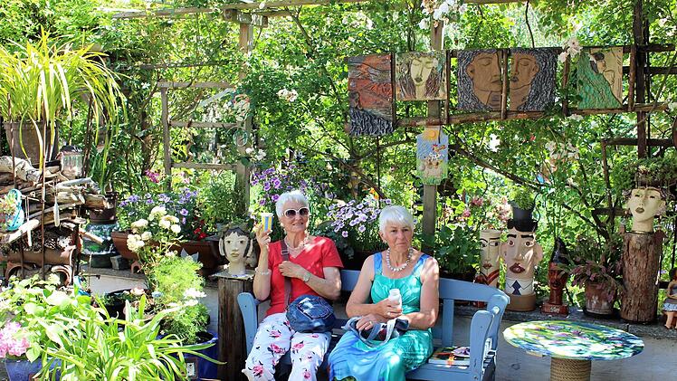 Kunst und Natur gehen im Garten von Elisabeth Hirschmann eine wunderbare  Verbindung ein, fanden auch diese beiden Besucherinnen.    Foto: Evi Seeger
