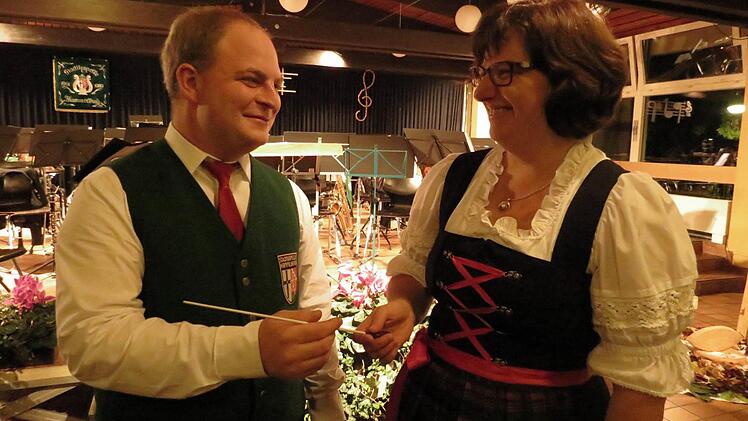 Christine Huppmann überreicht den Taktstocks an den neuen Dirigenten des Vororchesters, Tobias Frühwirth. Foto: Doris Bauer