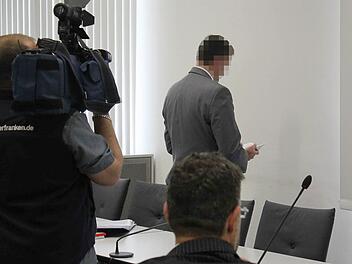 Der angeklagte Chefarzt dreht dem Publikum im Landgericht den Rücken zu und blättert in der Europäischen Konvention zum Schutz der Menschenrechte und Grundfreiheiten, aus der er gestern den Artikel 6 zitierte.   Foto: Peter Groscurth