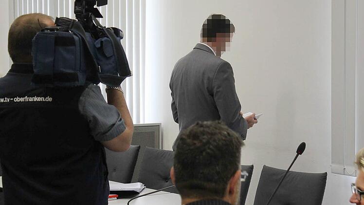 Der angeklagte Chefarzt dreht dem Publikum im Landgericht den Rücken zu und blättert in der Europäischen Konvention zum Schutz der Menschenrechte und Grundfreiheiten, aus der er gestern den Artikel 6 zitierte.   Foto: Peter Groscurth