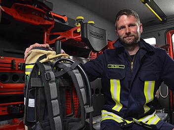 Oberzells Wehrf&uuml;hrer Christof Dorn mit einem der vier Atemschutzger&auml;te im Einsatzfahrzeug. Bei einem Ernstfall bleiben die Ger&auml;te derzeit ungenutzt.    Foto: Marah Naumann