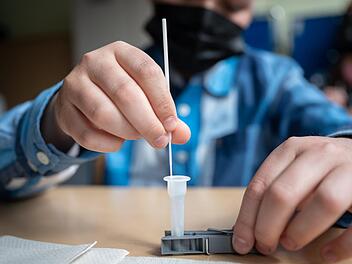 Ein Schüler führt im Klassenzimmer einen Selbsttest durch. Foto: Sebastian Gollnow/dpa