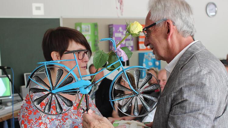 Stellvertretende Schulleiterin Tine Rehm verabschiedete Zenk mit einem Fahrrad - für den Garten. Foto: Yannick Hupfer