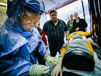 Ob ein Notarzt in dem Schutzanzug Blut abnehmen kann, prüft Gesundheitsamtsleiter Helmut Weiß an einem Dummy. Foto: Hendrik Steffens