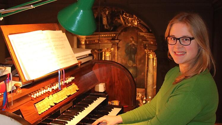 Auf der obersten Empore und mit Blick auf das Altarbild der Sulzthaler Marienkirche im Hintergrund sitzt Karolina Halbig am Manual der Orgel. Foto: Ralf Ruppert