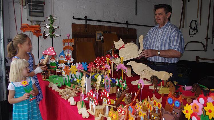 Peter Löffler aus Steinberg zeigt der vierjährigen Karla und ihrer vier Jahre älteren Schwester Anne seine kleinen Kunstwerke. Foto: Heike Schülein