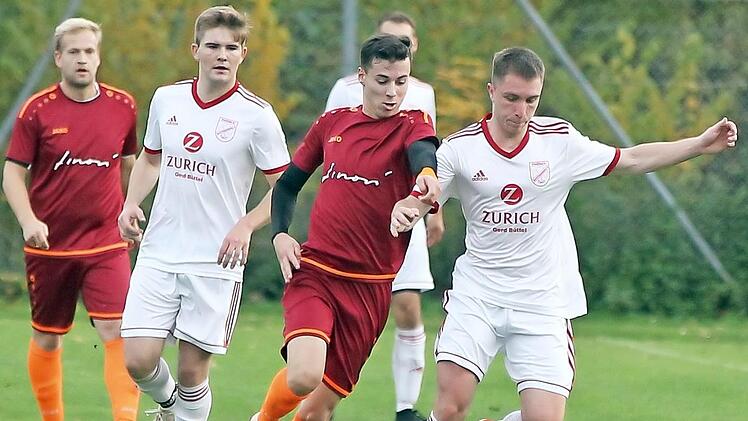 Das letzte Punktspiel in diesem Jahr hatten sich die Bezirksliga-Kicker des SC Sylvia Ebersdorf sicher anders vorgestellt. Beim FSV Buttenheim kassierten die Schützlinge von Trainer Dieter Kurth eine bittere 2:4-Schlappe und mussten die Tabellenführung an den direkten Kontrahenten abgeben. - In dieser Szene behauptet der Buttenheimer Patrick Kuwaczka (weißes Trikot) den Ball gegen den Ebersdorfer Tunahan Özer; im Hintergrund beobachtet Jakob Engelmann (links) den Zweikampf. Foto: Lisa Hümmer