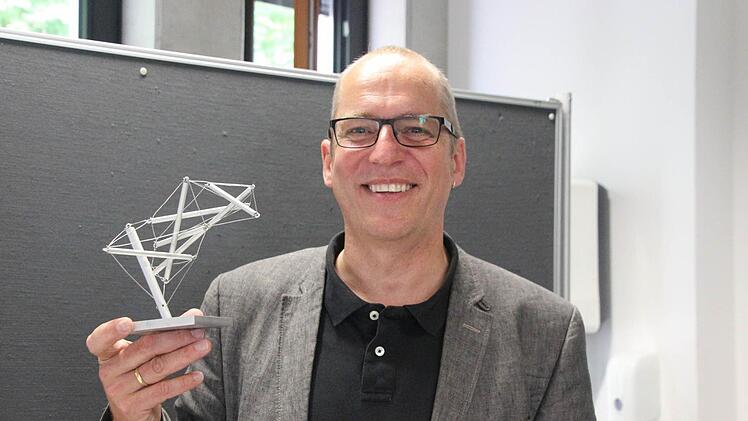 Dekan Friedemann Zeitler mit einem kleinen Modell der Tensegrety-Skulptur. Um diese Skulptur auf dem Campus aufstellen zu können, werden noch Sponsoren gesucht.