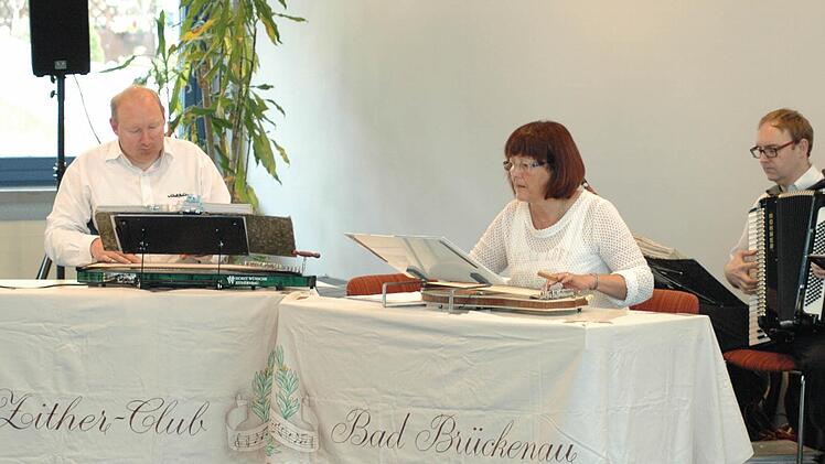 Guido Wolf, Elke Hüfner sowie Marco Wolf (Ziehharmonika) spielen mit ihrer Gruppe auch moderne Zither-Musik. Foto: Sebastian Schmitt-Mathea