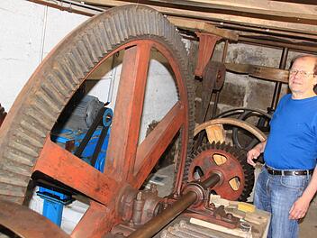 Fritz Müller vor der in Stand gesetzten, aber nicht vom Mühlrad angetriebenen Transmissionstechnik der Fuchsenmühle. Foto: Matthias Einwag