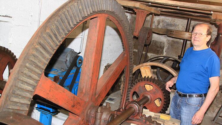 Fritz Müller vor der in Stand gesetzten, aber nicht vom Mühlrad angetriebenen Transmissionstechnik der Fuchsenmühle. Foto: Matthias Einwag