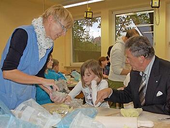 Bürgermeister Gerhard Preß (rechts) lässt sich von Julia und ihrer Fachlehrerin Sabine Scheler zeigen, wie aus kleinen Schnecken eine ganze Schale aus Ton getöpfert wird.  Foto: Rainer Lutz