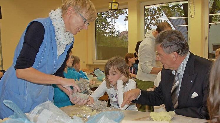 Bürgermeister Gerhard Preß (rechts) lässt sich von Julia und ihrer Fachlehrerin Sabine Scheler zeigen, wie aus kleinen Schnecken eine ganze Schale aus Ton getöpfert wird.  Foto: Rainer Lutz
