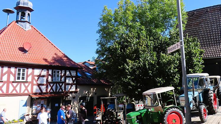 Oldtimer vor dem historischen Gemeindehaus - Fr&uuml;hschoppen und Versorgungsst&auml;nde dahinter.