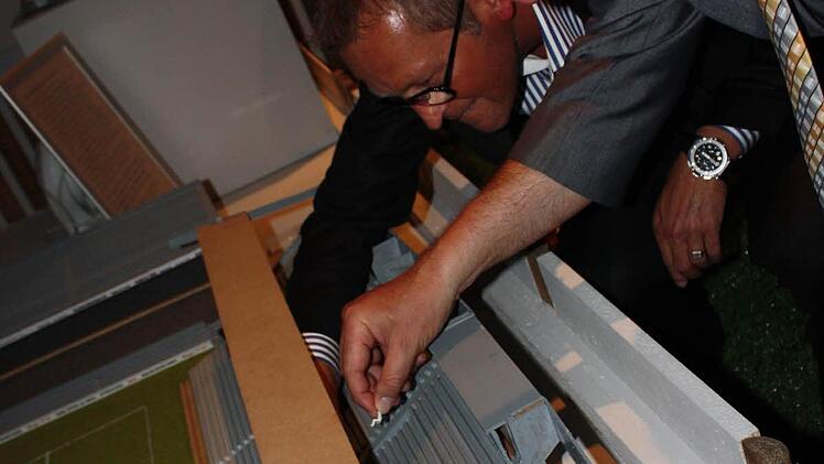 Bürgermeister Gerald Brehm (r.) und Gerald Fischer von der Firma Medwork setzen die ersten Figuren in das Modell des Stadions.