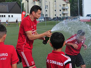Auf dem Platz eine Klasse für sich - beim Feiern ganz vorn: Daniel Sam nach dem Landesliga-Aufstieg mit Coburger Jungs. Der Mittelstürmer der Vestekicker spielte für den 1. FC Nürnberg, die SpVgg Selbitz, den FC Bayern Hof, die SpVgg Bayreuth und den VfL Frohnlach. Die Sektkorken ließ er in den letzten 15 Jahren öfters knallen, denn seine Amateurkarriere ist gespickt mit außergewöhnlichen Höhepunkten. Foto: Hagen Lehmann