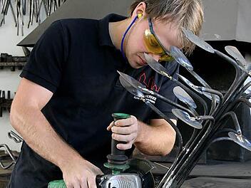 Eine Personengruppe, die immer kleiner wird: Fachkräfte wie Tobias Kleinhans. Er bearbeitet mit dem Winkelschleifer einen Kunstgegenstand aus Metall. Foto: Archiv (fp)