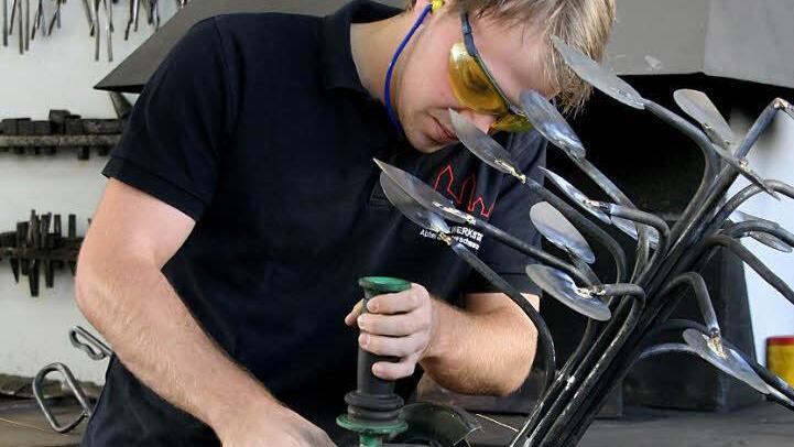 Eine Personengruppe, die immer kleiner wird: Fachkräfte wie Tobias Kleinhans. Er bearbeitet mit dem Winkelschleifer einen Kunstgegenstand aus Metall. Foto: Archiv (fp)