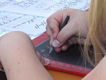 Eine Herausforderung für die Jüngeren  beim Spielfest auf Schloss Aschach: das Schreiben mit Griffel Foto:  Björn Hein