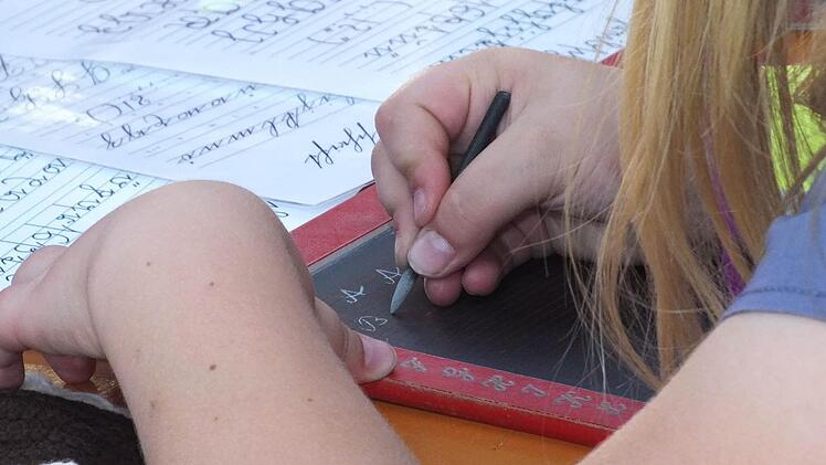 Eine Herausforderung für die Jüngeren  beim Spielfest auf Schloss Aschach: das Schreiben mit Griffel Foto:  Björn Hein