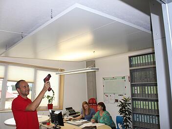 Karl Pröls misst mit dem Laser-Thermometer an seiner Klimadecke 18 Grad. Diese Frische wird an die Raumluft abgegeben. Foto: Andreas Dorsch