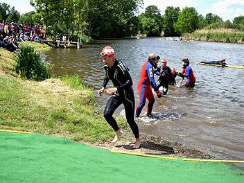 Die Helfer der DLRG unterst&uuml;tzen die Athleten nach dem Schwimmen, um unfallfrei aus dem Main zu steigen. Zahlreiche Zuschauer am Ufer verfolgen dies regelm&auml;&szlig;ig, so auch an diesem Pfingststonntag. Foto: D. Radziej