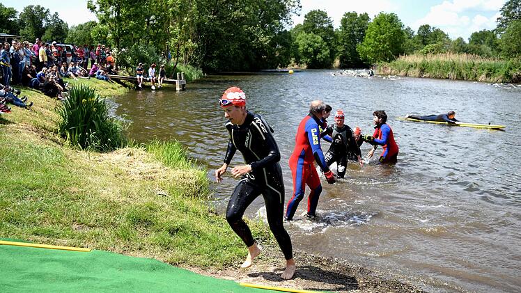 Die Helfer der DLRG unterst&uuml;tzen die Athleten nach dem Schwimmen, um unfallfrei aus dem Main zu steigen. Zahlreiche Zuschauer am Ufer verfolgen dies regelm&auml;&szlig;ig, so auch an diesem Pfingststonntag. Foto: D. Radziej
