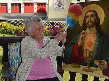 Auch mit 92 Jahren lässt es sich Josefine Zwosta nicht nehmen, die Altarbilder vom Staub zu befreien. Vor 84 Jahren war sie das erste Mal an der Aufstellung und Ausschmückung eines Fronleichnamsaltars in Rothenkirchen beteiligt. Foto: Karl-Heinz Hofmann