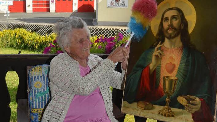 Auch mit 92 Jahren lässt es sich Josefine Zwosta nicht nehmen, die Altarbilder vom Staub zu befreien. Vor 84 Jahren war sie das erste Mal an der Aufstellung und Ausschmückung eines Fronleichnamsaltars in Rothenkirchen beteiligt. Foto: Karl-Heinz Hofmann