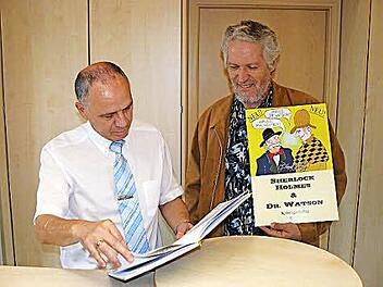 Bürgermeister Franz Uome (links) blätterte bei einem Pressetermin anlässlich der Buchvorstellung im Marktleugaster Rathaus interessiert im ersten der fünf geplanten Werke von Axel Bochnia (rechts). Foto: Wulf
