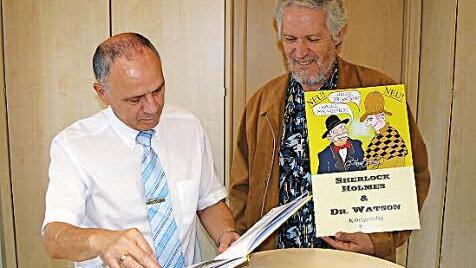 Bürgermeister Franz Uome (links) blätterte bei einem Pressetermin anlässlich der Buchvorstellung im Marktleugaster Rathaus interessiert im ersten der fünf geplanten Werke von Axel Bochnia (rechts). Foto: Wulf